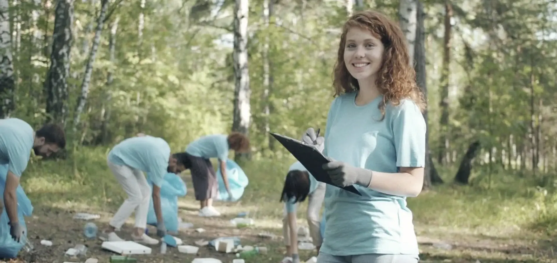 A volunteer picking up litter during a forest clean-up